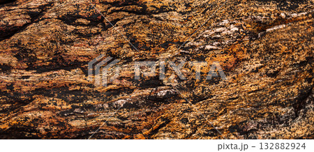Close-up of layered sedimentary rock surface with orange tones Close-up of layered sedimentary rock surface with orange tones 132882924
