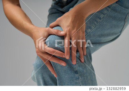 Close-up of woman touching her knee showing discomfort and joint pain 132882959