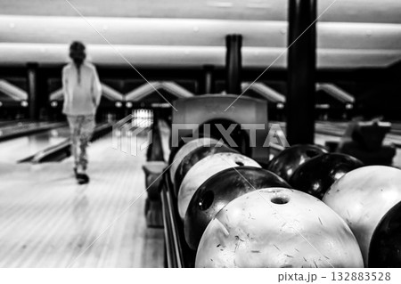 Bowler aiming for a strike in a modern bowling alley during an evening outing with friends Bowler aiming for a strike in a modern bowling alley during an evening outing with friends 132883528