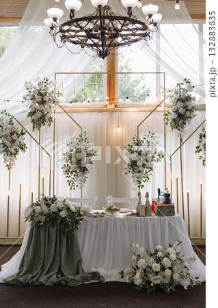 Elegant wedding banquet hall with floral decor and white drapery under wooden ceiling Elegant wedding banquet hall with floral decor and white drapery under wooden ceiling 132883835