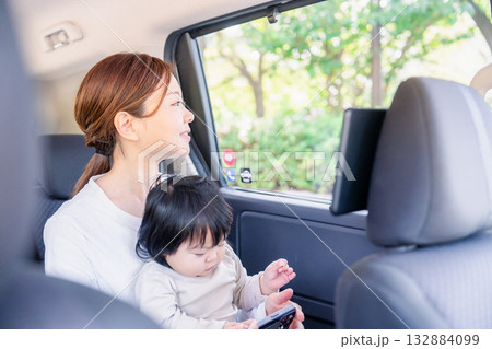 小さい子供と一緒にタクシーに乗るお母さん 132884099