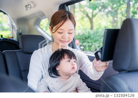 小さい子供と一緒にタクシーに乗るお母さん 132884126