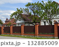 A row of one-story houses behind a metal fence, Russia 132885009