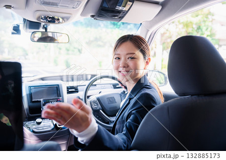 決済の案内をする若い女性のタクシー運転手 132885173