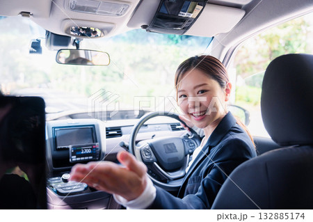 決済の案内をする若い女性のタクシー運転手 132885174