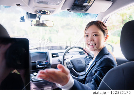決済の案内をする若い女性のタクシー運転手 132885176