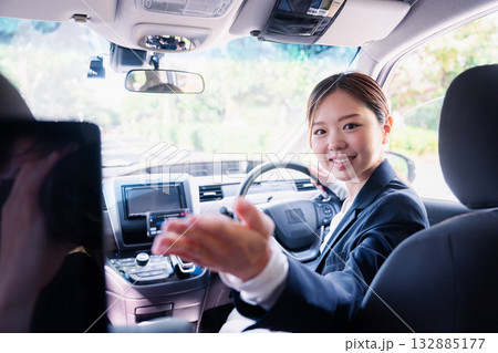 決済の案内をする若い女性のタクシー運転手 132885177