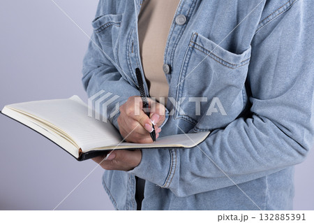 Woman is writing in a notebook Woman is writing in a notebook 132885391