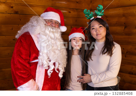 The family is posing for a picture with Santa Claus during the Christmas holiday 132885408