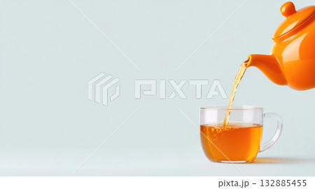 Orange Teapot Pouring Tea into Glass Cup Orange Teapot Pouring Tea into Glass Cup 132885455