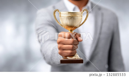 Man holding golden trophy in hand 132885533