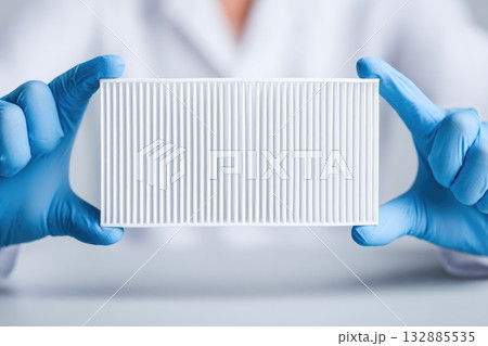 Lab technician holding white air filter 132885535