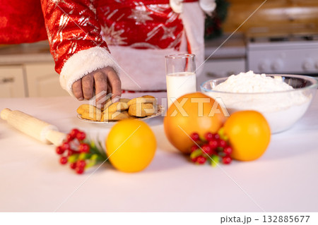 anta Claus is preparing for Christmas by reaching for a cookie 132885677