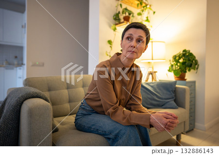 Anxious worried woman waiting news, nervous female crossing arms on sofa in stressful anticipation Anxious worried woman waiting news, nervous female crossing arms on sofa in stressful anticipation 132886143