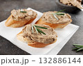 Bruschetta with chicken liver pate and rosemary on a grey background.  132886144
