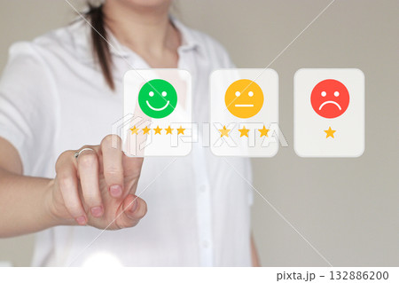 Female hand selecting a smiley face rating on transparent digital screen. Customer review, satisfaction level, and quality control in modern business communication, feedback, digital evaluation system Female hand selecting a smiley face rating on transparent digital screen. Customer review, satisfaction level, and quality control in modern business communication, feedback, digital evaluation system 132886200