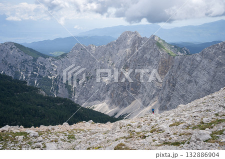 Small hiker enjoying view on vast mountainous landscape around him, Triglav National Park, Slovenia 132886904