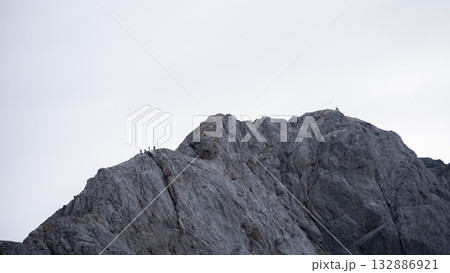 Group of hikers descending exposed rocky ridgeline near mountain summit, Triglav Nat Park, Slovenia 132886921