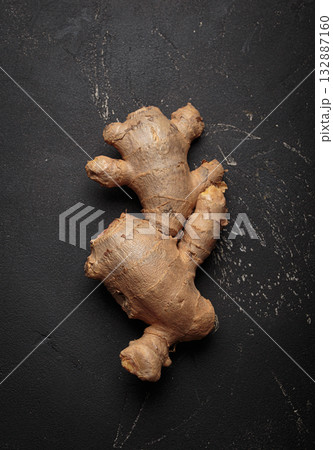 Fresh raw single ginger root black dark background healthy alternative medicine immunity 132887160