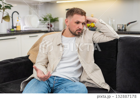 Young man with exhausted mood after rough day sits quiet and reflects on stress low energy and calm 132887178