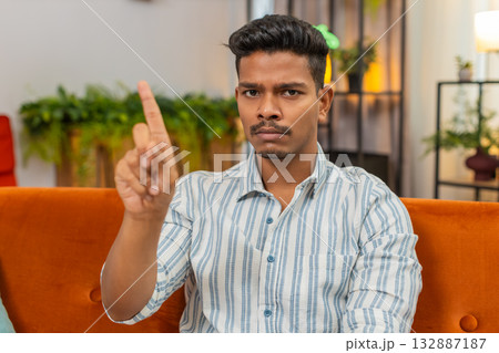 Indian man waves finger no no to camera shows refusal disagreement gesture unhappy mood clear signal Indian man waves finger no no to camera shows refusal disagreement gesture unhappy mood clear signal 132887187
