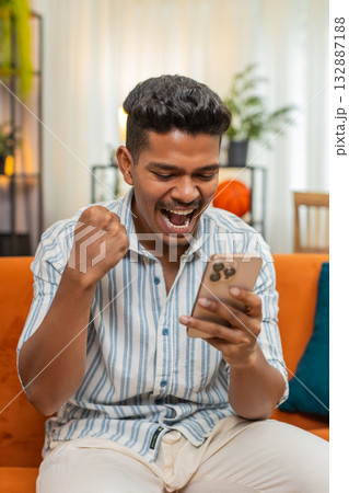 Indian man celebrates online game win after smartphone alert shows prize news joyful happy reaction Indian man celebrates online game win after smartphone alert shows prize news joyful happy reaction 132887188