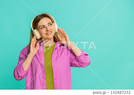 Woman putting on wireless headphones starts moving to rhythm enjoying music and feeling the beat 132887232