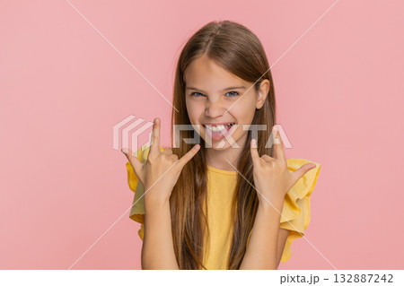 Child girl kid dancing with excitement showing rock-and-roll gesture with cool confident expression 132887242