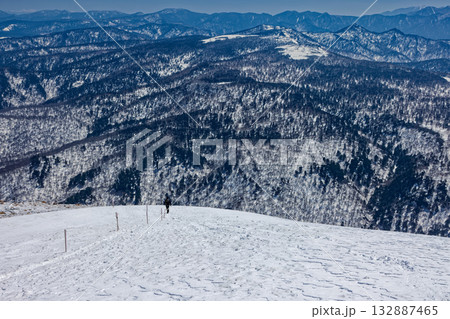 残雪期の至仏山から尾瀬ヶ原へ向かう登山者とアヤメ平の眺め 132887465