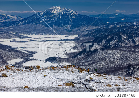 残雪期の至仏山から尾瀬ヶ原へ向かう登山者と燧ヶ岳の眺め 132887469