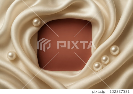 Elegant fabric with pearls surrounding a blank square for beauty product display on soft cream 132887581