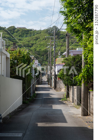 先に山のある晴れて路上に建物の影が出来た田舎の路地裏の道 132887790