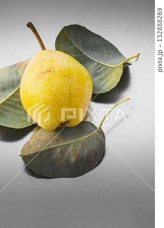 Pear and its leaves lie on an abstract surface, composite fashion photo 132888269