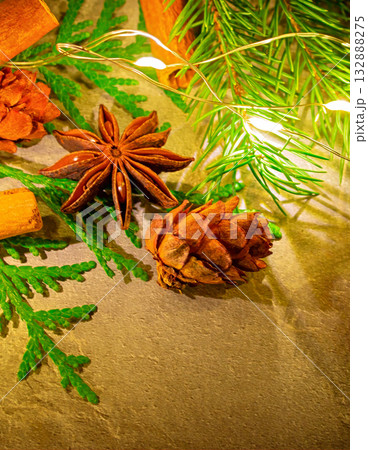 A Christmas photo featuring natural star anise and cinnamon sticks, along with fir branches and pine cones A Christmas photo featuring natural star anise and cinnamon sticks, along with fir branches and pine cones 132888275