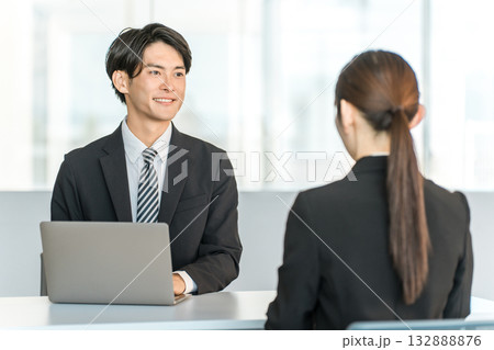 女性客,ビジネスウーマンと商談・接客・打ち合わせする若いアジア人ビジネスマン 132888876