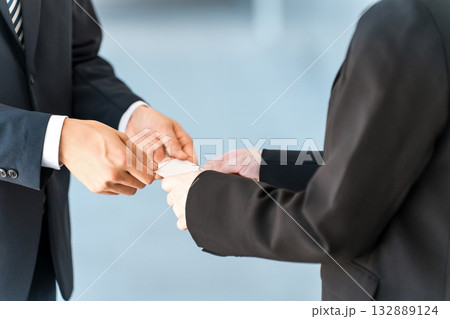 名刺交換するビジネスマンとビジネスウーマンの手元 132889124