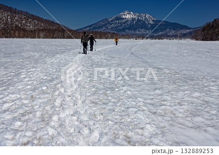 残雪期の尾瀬ヶ原を行く登山者と燧ヶ岳 132889253