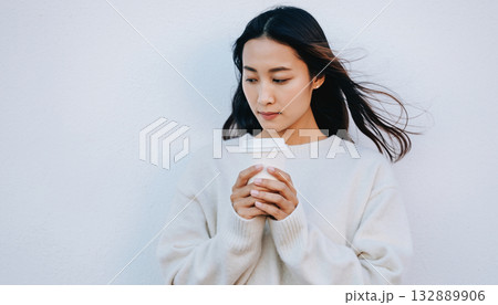 日本人女性がオフホワイトのセーターでコーヒーを持つポートレート 132889906