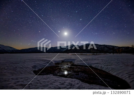 残雪期の尾瀬ヶ原から見る西に傾いた月・冬の星座と景鶴山 残雪期の尾瀬ヶ原から見る西に傾いた月・冬の星座と景鶴山 132890071