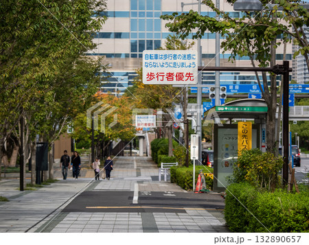 自転車の通行が許可された歩道と「歩行者優先」の注意喚起標識 132890657