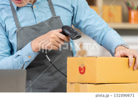 Entrepreneur focusing on package details with barcode scanner Entrepreneur focusing on package details with barcode scanner 132890671