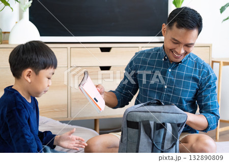 Back to School. Father helping son prepare for school with a backpack. Back to School. Father helping son prepare for school with a backpack. 132890809