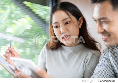 Digital Collaboration and Insights. Colleagues discussing project details on smartphone in bright workspace. Digital Collaboration and Insights. Colleagues discussing project details on smartphone in bright workspace. 132890936