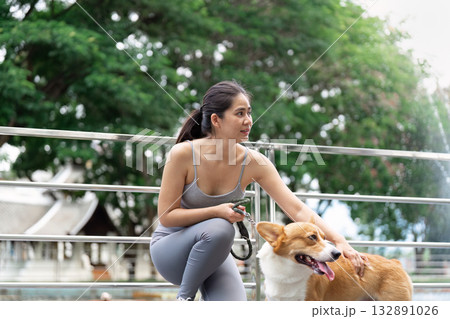 Wellness and Exercise. Young woman enjoying outdoor dog walk for fitness and mental health. Wellness and Exercise. Young woman enjoying outdoor dog walk for fitness and mental health. 132891026