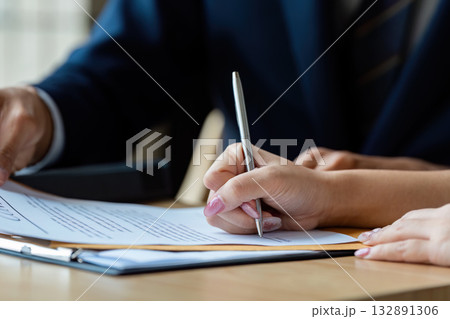 Business Agreement Signing. Professional woman signing important documents in a corporate setting. 132891306