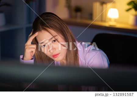 Working Late. Focused woman looking at her computer screen late at night. Working Late. Focused woman looking at her computer screen late at night. 132891587