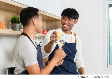 Couple Cooking Together. Joyful men preparing food in a modern kitchen. Couple Cooking Together. Joyful men preparing food in a modern kitchen. 132891636