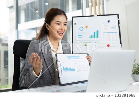 Virtual Meeting and Engagement. Happy businesswoman presenting financial data on video call. Virtual Meeting and Engagement. Happy businesswoman presenting financial data on video call. 132891969