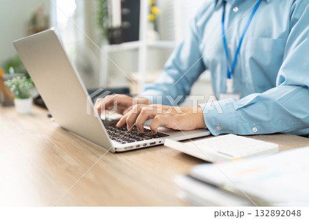 Remote Work and Productivity. Close-up of hands typing on laptop in a home office. 132892048