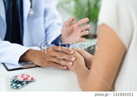 Patient Engagement. Doctor discussing treatment options while holding patient hand. 132892051